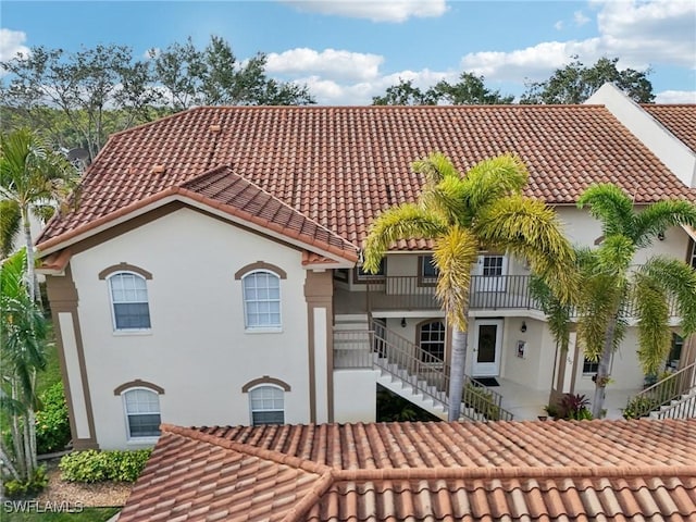242 Newport Dr Unit 502, Naples, FL 34114 - back of house with stairway, stucco siding, and a tiled roof