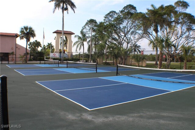 view of tennis court with community basketball court and fence