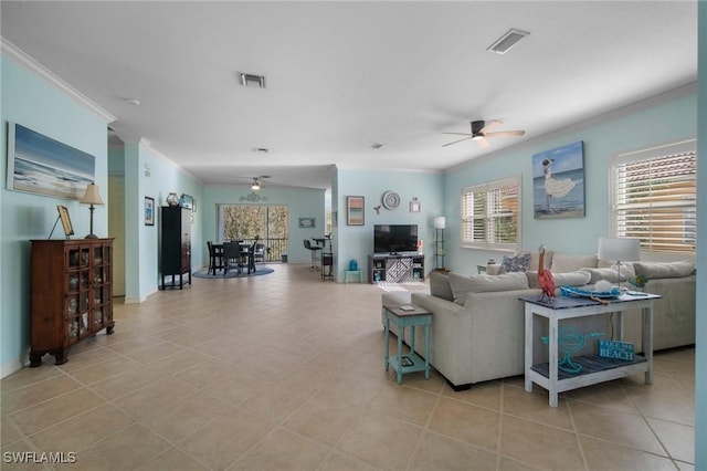 tiled living room with ceiling fan and ornamental molding