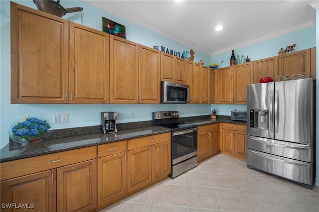 kitchen featuring light tile patterned floors, crown molding, appliances with stainless steel finishes, and dark stone counters