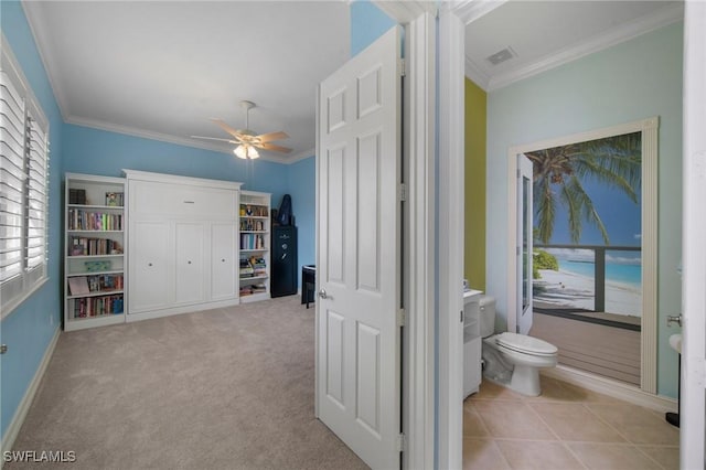 interior space with ceiling fan, toilet, and ornamental molding