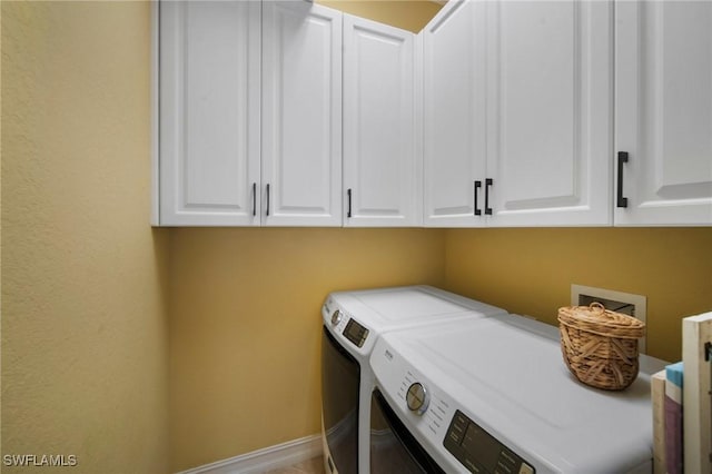 washroom featuring cabinets and washer and dryer