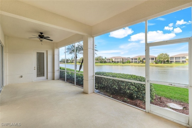 unfurnished sunroom featuring a water view and ceiling fan