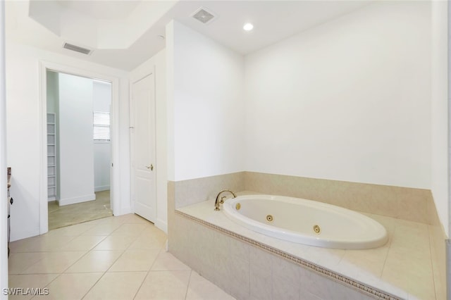 bathroom featuring tiled bath and tile patterned flooring