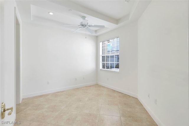 spare room featuring light tile patterned floors, a raised ceiling, and ceiling fan