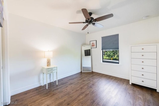 unfurnished bedroom with ceiling fan and dark wood-type flooring