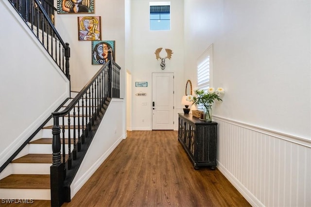 entryway with a towering ceiling and dark hardwood / wood-style floors