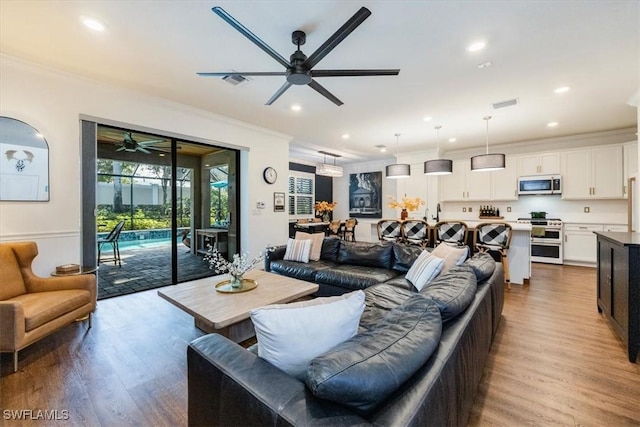 living room with hardwood / wood-style flooring and crown molding