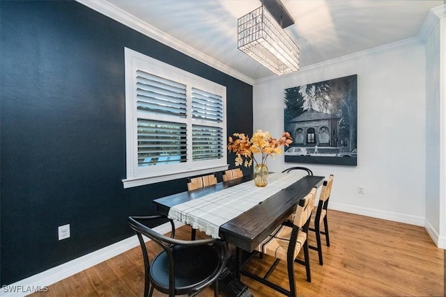 dining area with light hardwood / wood-style flooring, a chandelier, and ornamental molding