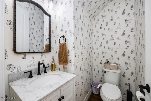 bathroom with vanity, toilet, and wood-type flooring