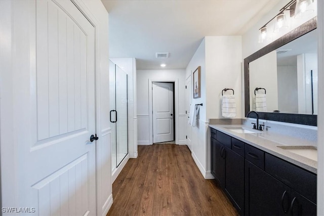 bathroom with vanity, an enclosed shower, and hardwood / wood-style flooring