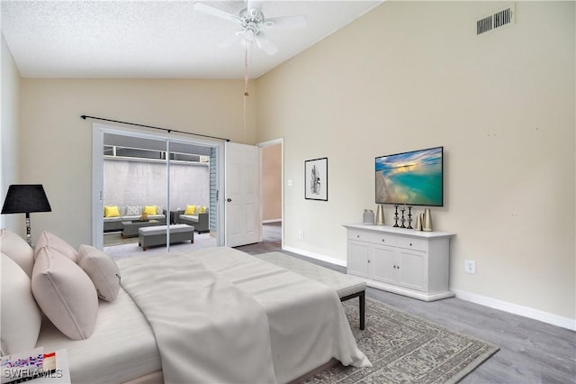 bedroom with a textured ceiling, ceiling fan, vaulted ceiling, and light wood-type flooring