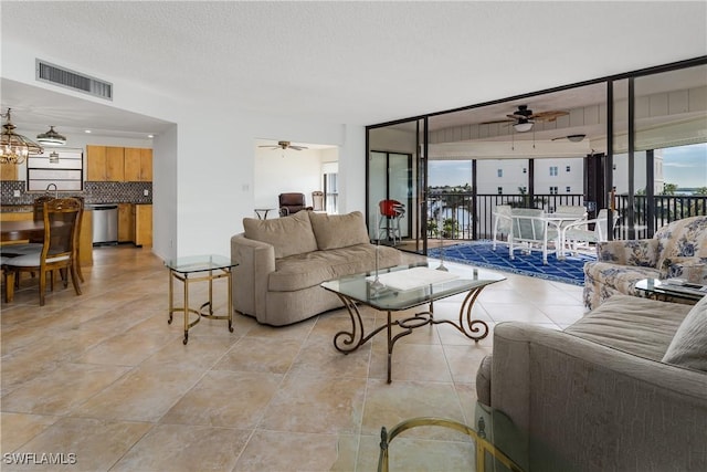 living room with ceiling fan and a textured ceiling