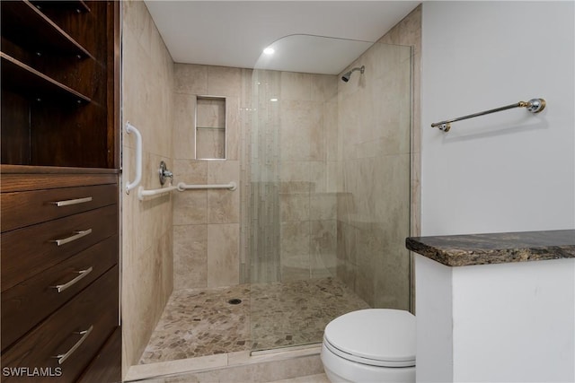 bathroom featuring tiled shower and toilet