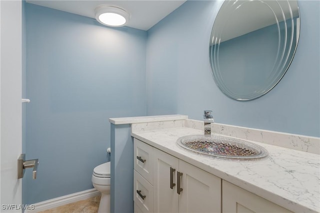 bathroom featuring tile patterned floors, vanity, and toilet