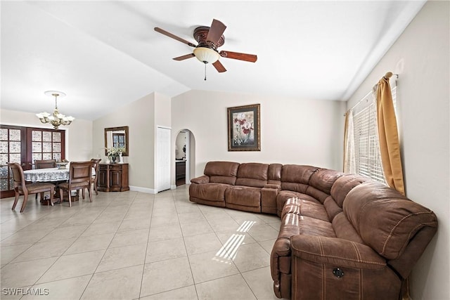 tiled living room featuring ceiling fan with notable chandelier and lofted ceiling