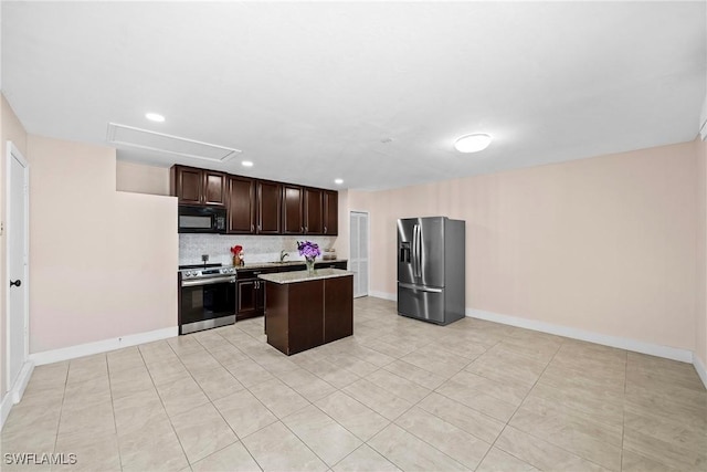 kitchen with decorative backsplash, dark brown cabinetry, stainless steel appliances, sink, and a center island