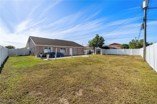 back of house with a lawn, a storage unit, and a patio area