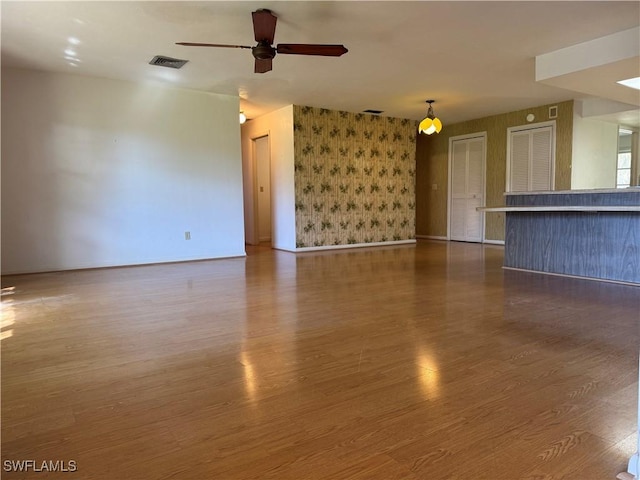 unfurnished living room featuring dark hardwood / wood-style floors and ceiling fan