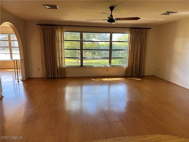 spare room with plenty of natural light, ceiling fan, and light hardwood / wood-style flooring