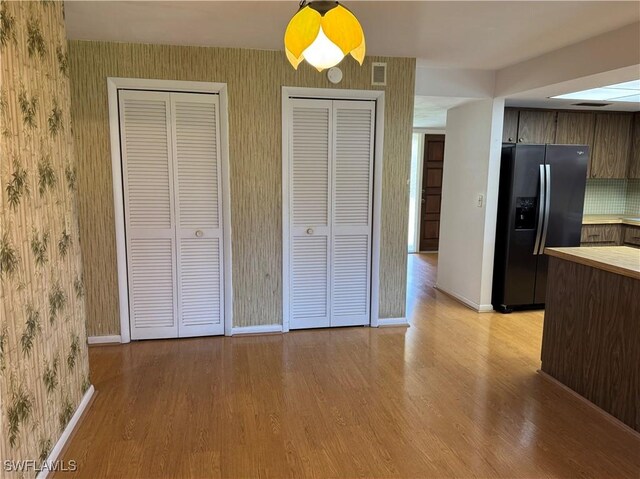 kitchen featuring stainless steel fridge with ice dispenser and light hardwood / wood-style flooring