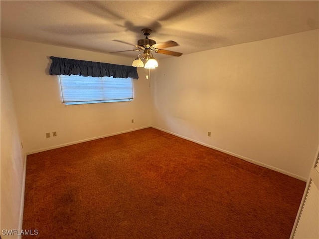 unfurnished room with dark carpet and ceiling fan