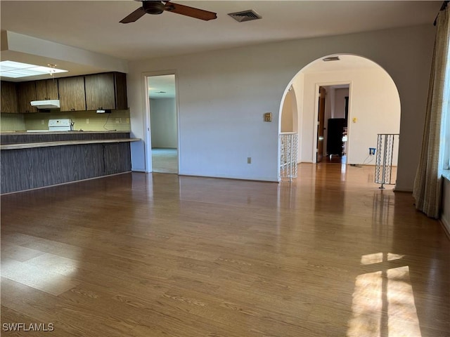 unfurnished living room with wood-type flooring and ceiling fan