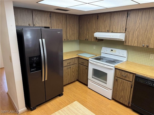 kitchen featuring stainless steel fridge, white range with electric cooktop, backsplash, black dishwasher, and light hardwood / wood-style floors