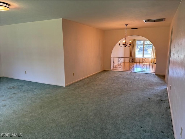 unfurnished living room featuring carpet and an inviting chandelier