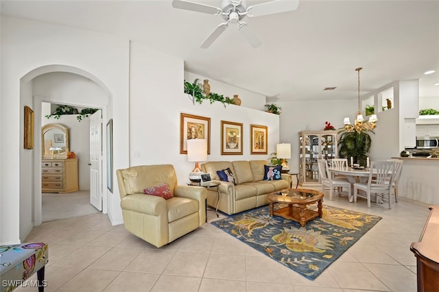 living room featuring light tile patterned floors and ceiling fan with notable chandelier