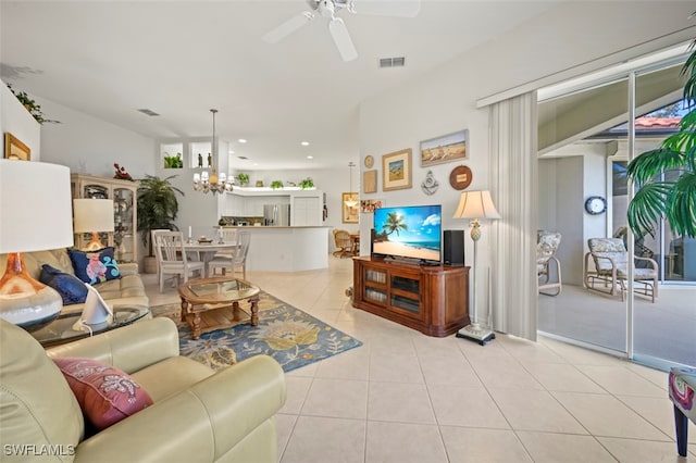 tiled living room featuring ceiling fan with notable chandelier