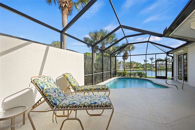 view of swimming pool with glass enclosure, a water view, and a patio