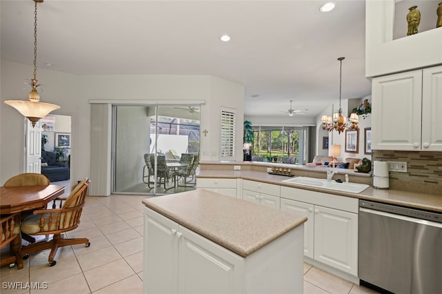 kitchen featuring stainless steel dishwasher, sink, light tile patterned floors, white cabinetry, and hanging light fixtures