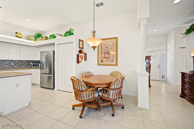 dining space featuring light tile patterned floors and decorative columns