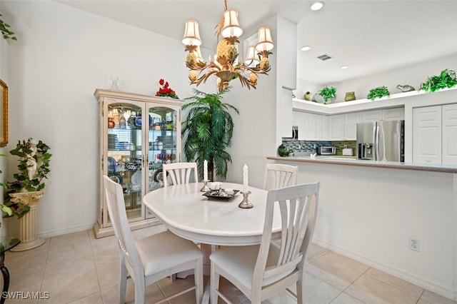 tiled dining space featuring a notable chandelier