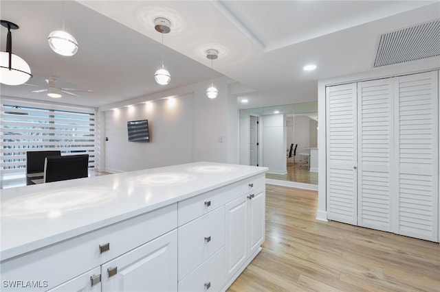 kitchen featuring white cabinets, light wood-type flooring, decorative light fixtures, and ceiling fan