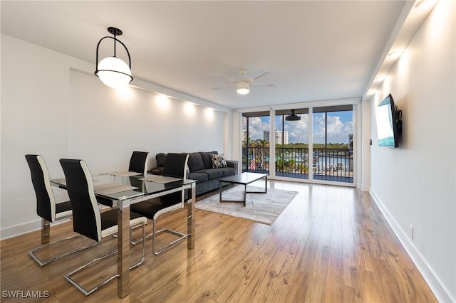 living room featuring light wood-type flooring, a wall of windows, and ceiling fan