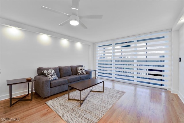 living room featuring ceiling fan, light hardwood / wood-style flooring, and expansive windows