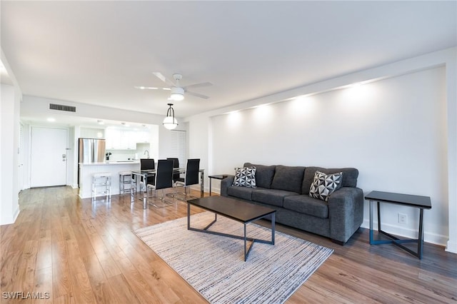 living room with ceiling fan and hardwood / wood-style floors