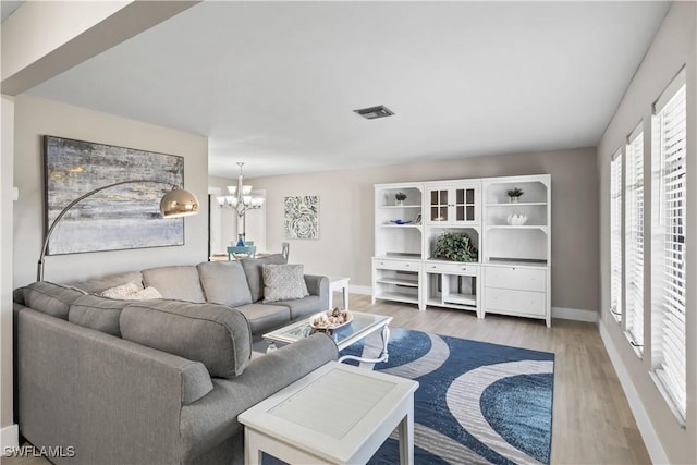 living room featuring hardwood / wood-style flooring and an inviting chandelier