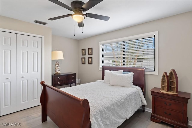 bedroom with ceiling fan, a closet, and light hardwood / wood-style flooring