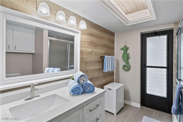 bathroom with hardwood / wood-style floors, vanity, and wooden walls