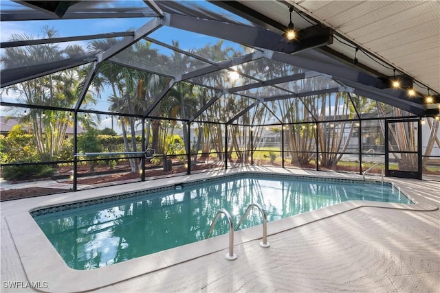 view of pool with glass enclosure and a patio area