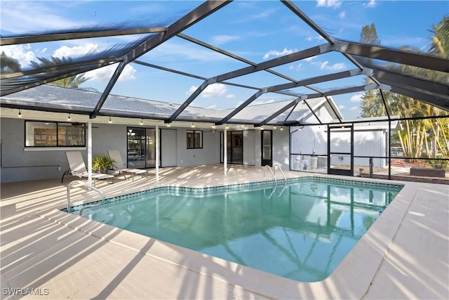 view of swimming pool featuring glass enclosure, ceiling fan, and a patio