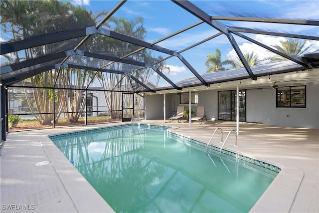 view of swimming pool featuring a patio area, ceiling fan, and a lanai