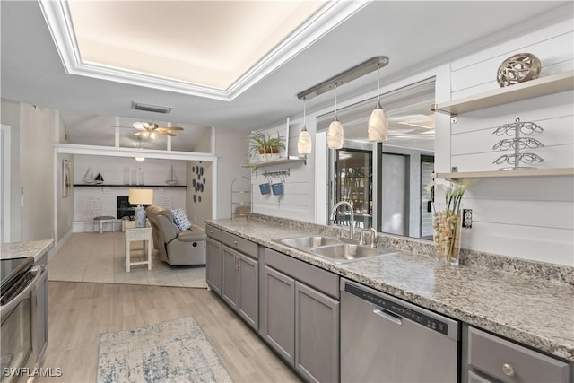 kitchen featuring gray cabinetry, sink, stainless steel dishwasher, ceiling fan, and decorative light fixtures