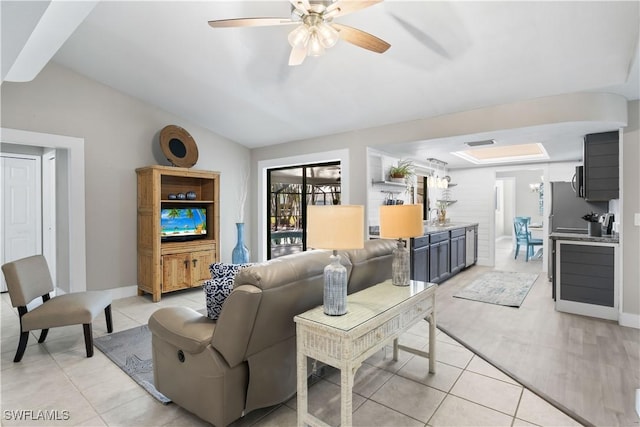 living room featuring light tile patterned floors, vaulted ceiling, and ceiling fan