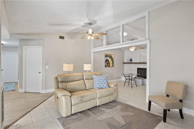 tiled living room with ceiling fan, a fireplace, and lofted ceiling