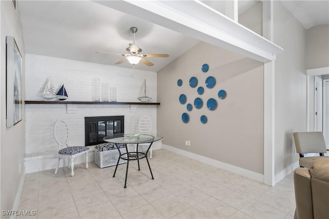 tiled dining area featuring ceiling fan and a fireplace