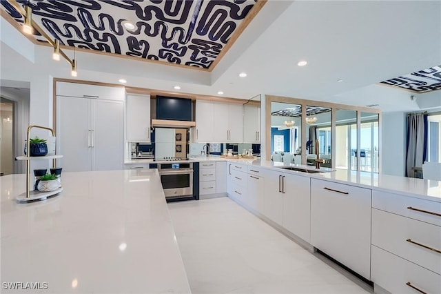 kitchen with wall chimney exhaust hood, sink, white cabinets, and oven